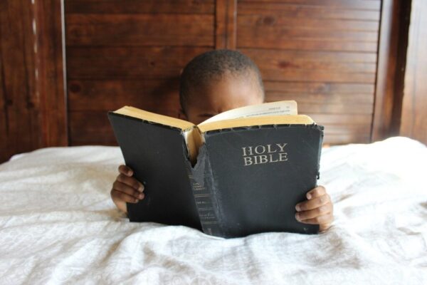 Child reading the Bible. 
